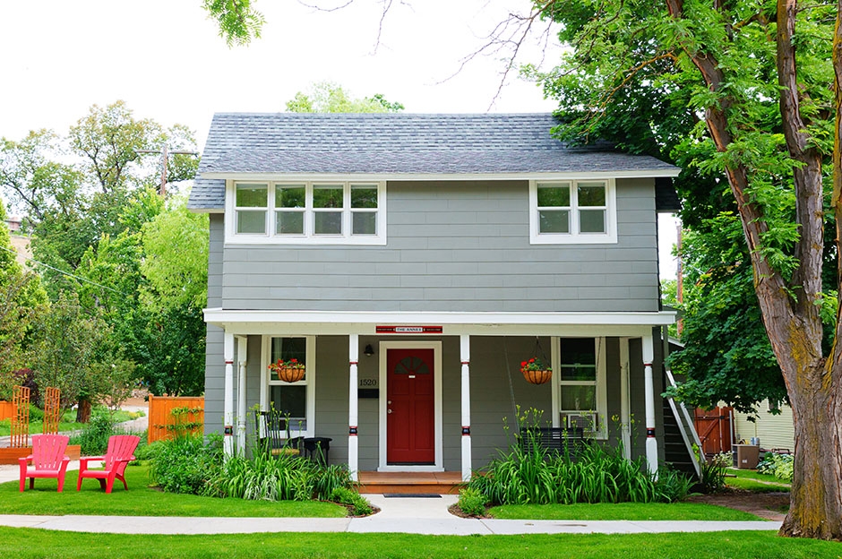 small grey house with lush yard